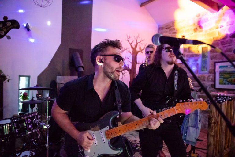 guitarists singing and a saxophone