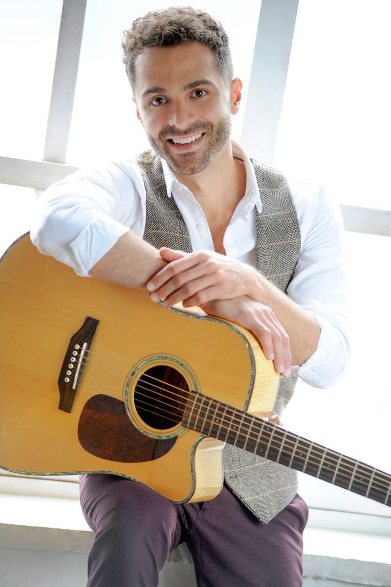 Singer holding acoustic guitar