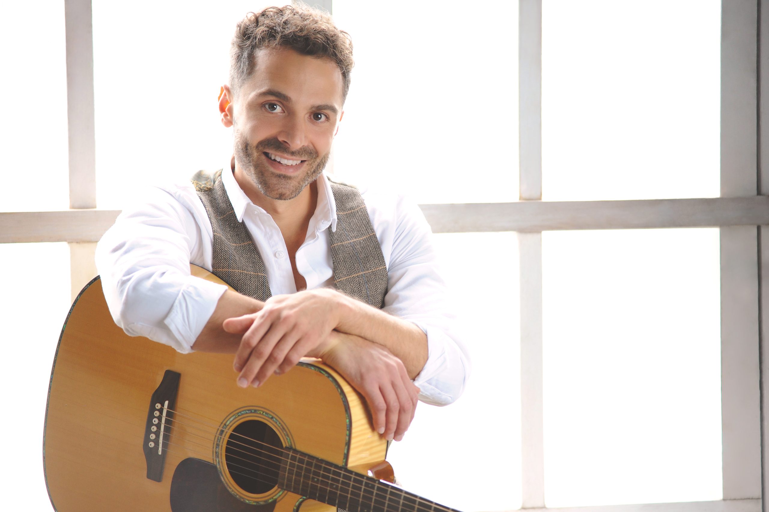 Singer sat down leaning on guitar